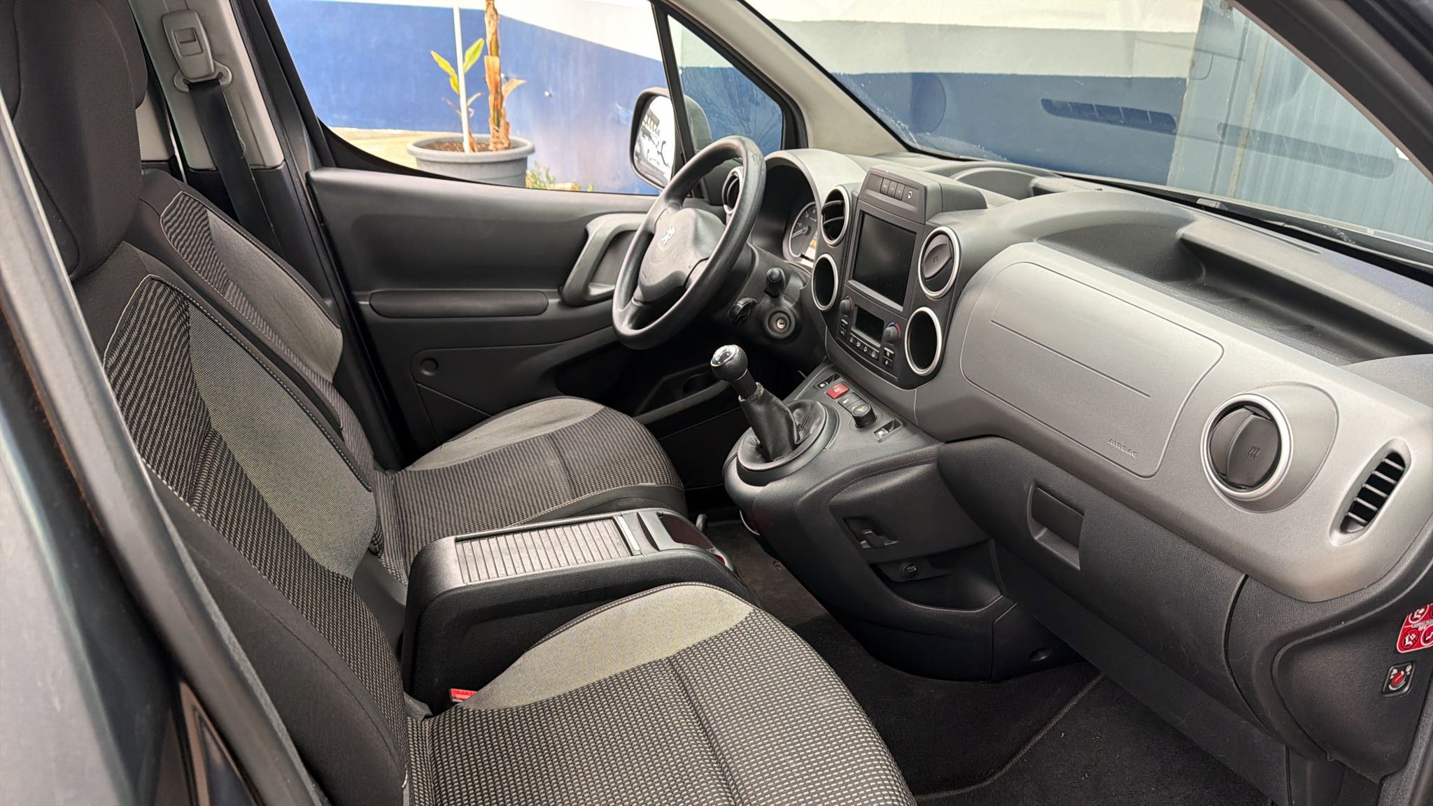 Interior de un vehículo con asientos cómodos y un tablero moderno, incluyendo volante, palanca de cambios y sistema de entretenimiento. Ideal para destacar características de diseño y funcionalidad del automóvil.