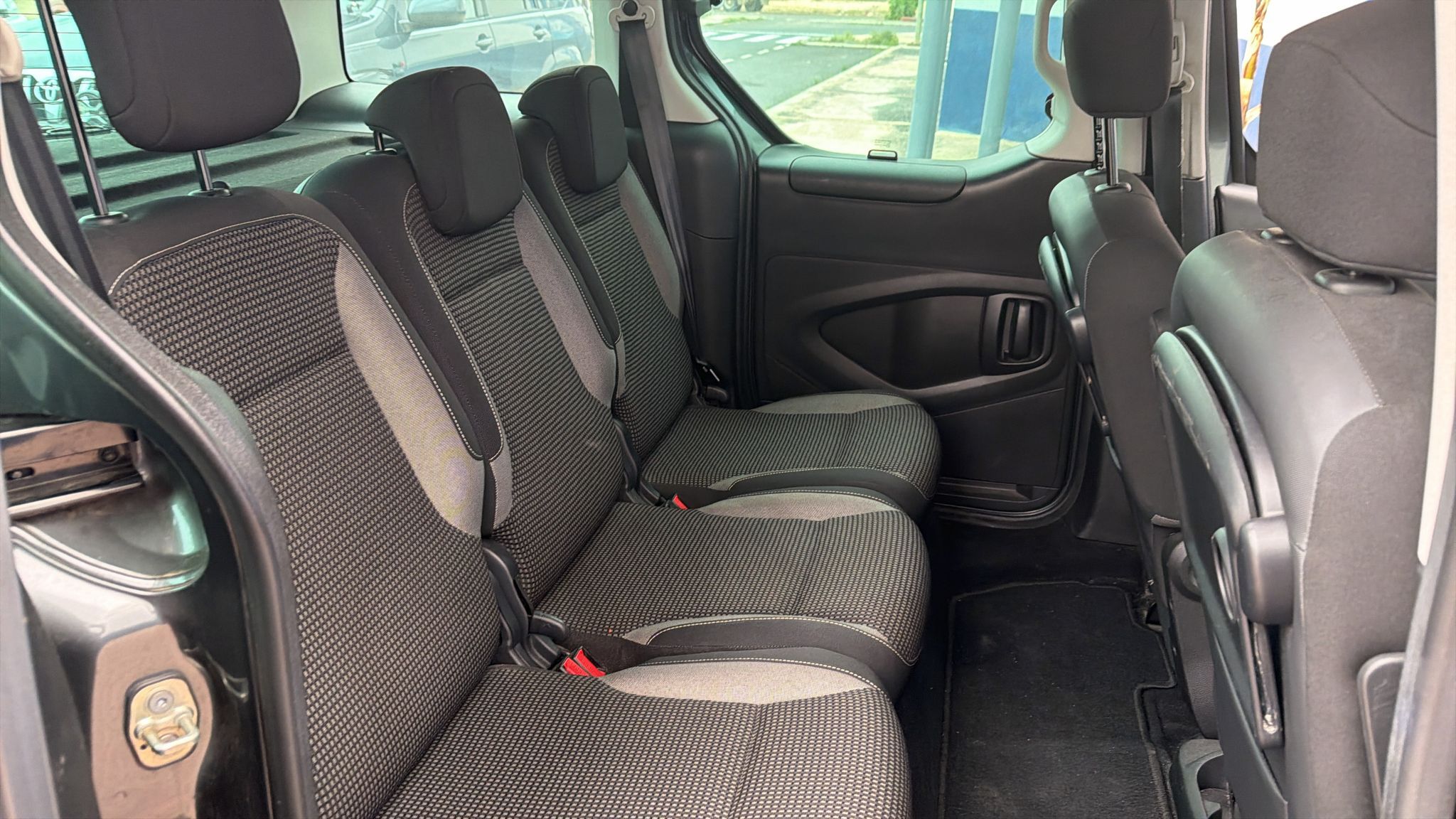 Asientos traseros de un vehículo con tapicería en tonos grises, mostrando un diseño moderno y cómodo. Ideal para viajes familiares o de grupo.