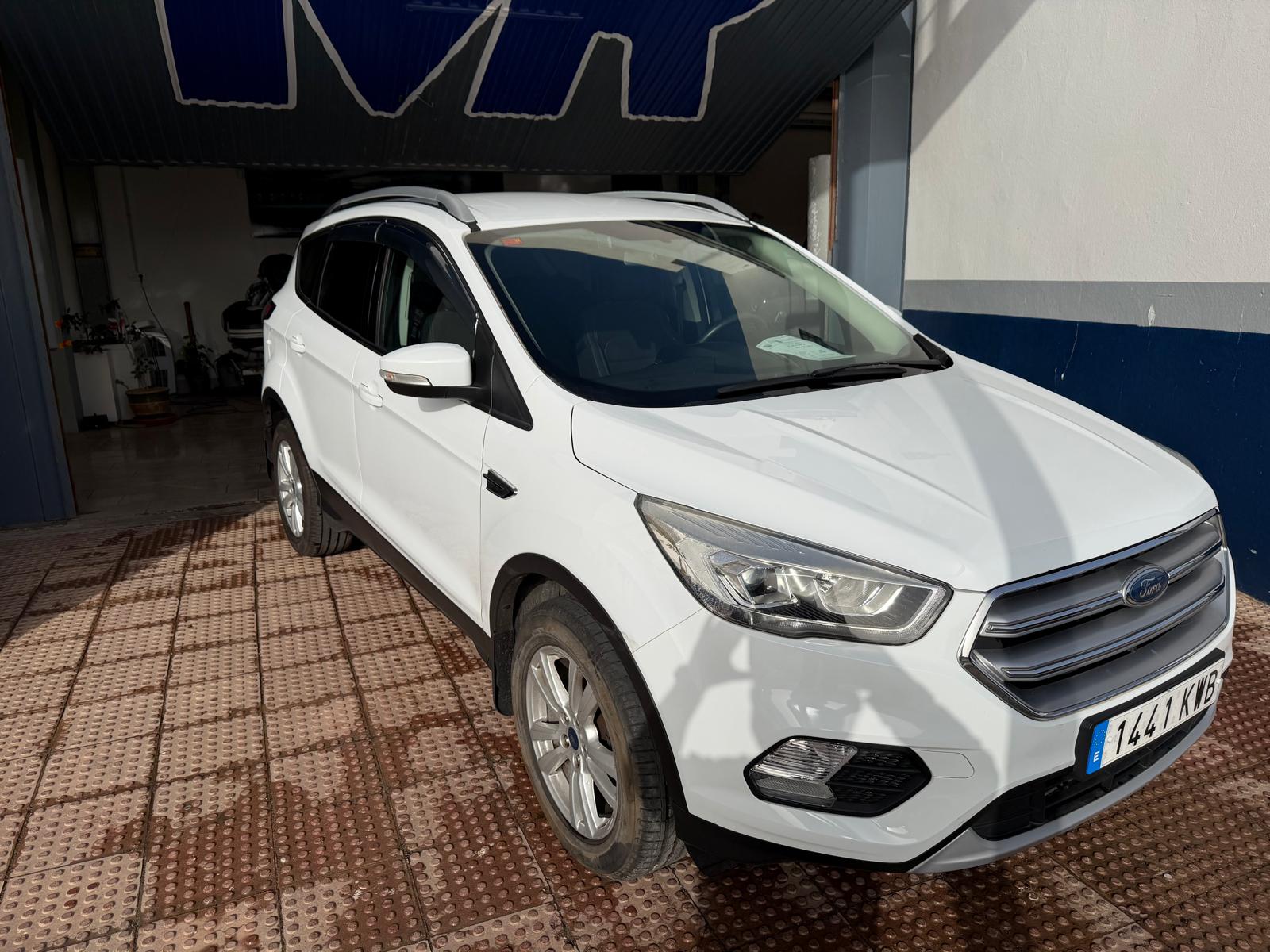 SUV blanca Ford en un taller, vista lateral con detalles del diseño y matrícula visible. Ideal para resaltar características de vehículos y servicios de mantenimiento.