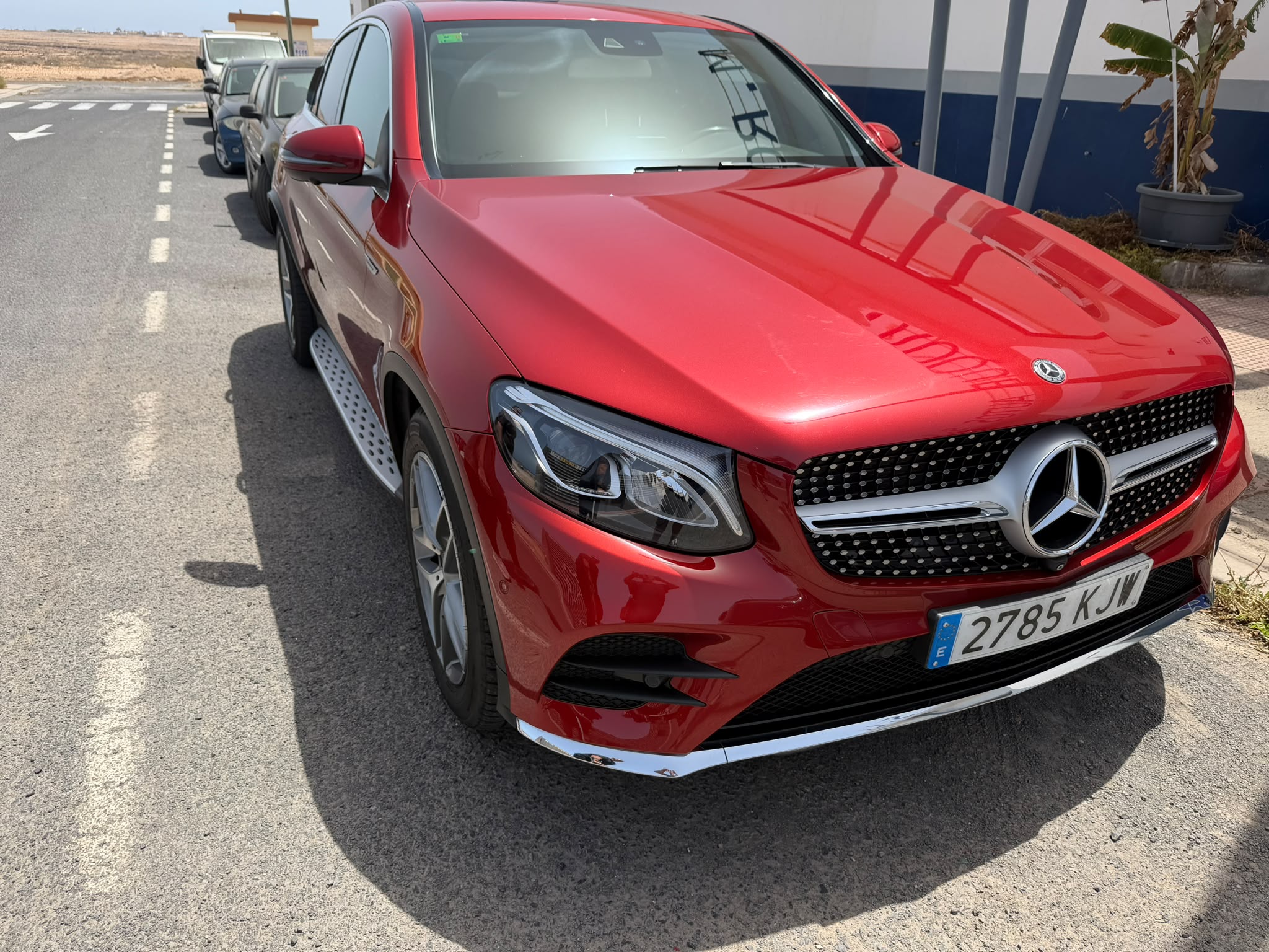 SUV Mercedes-Benz GLC rojo estacionado en la calle, con matrícula 2785 KJW, mostrando su diseño elegante y moderno.