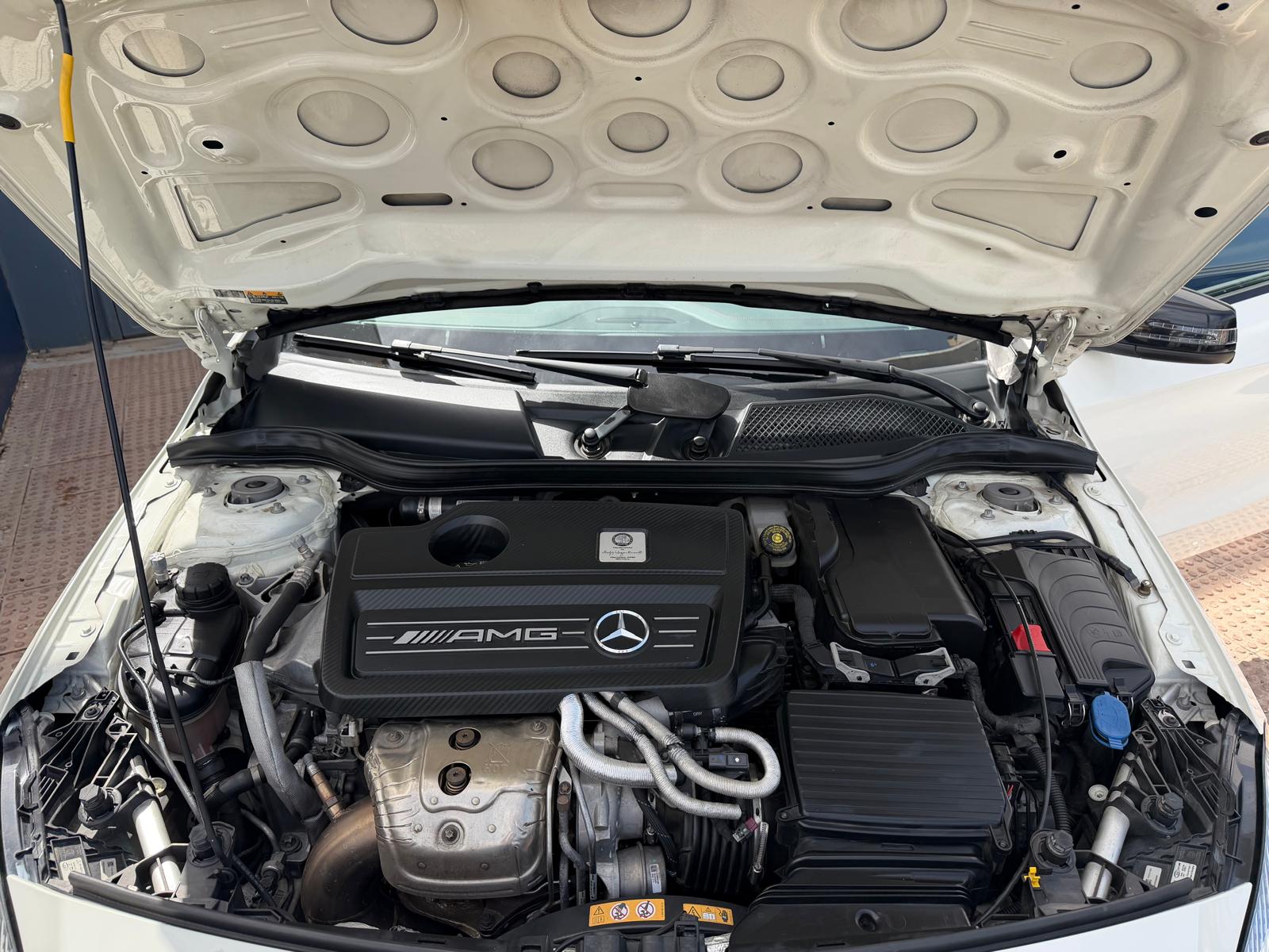 Motor de un automóvil Mercedes-AMG con el capó abierto, mostrando detalles del sistema de inyección y componentes mecánicos, ideal para entusiastas de la automoción y mantenimiento de vehículos.